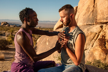 Photographs of a young black gay man practicing Reiki in the desert.  - 619527338