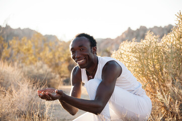 Photographs of a young black gay man practicing Reiki in the desert. 