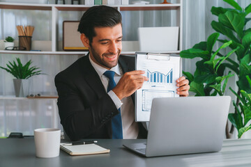 Professional businessman in black suit, present financial data or BI paper via laptop during online...