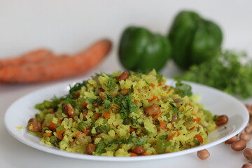 Vegetable Poha is a quick breakfast or snack made of beaten rice or flattened rice along peanuts, carrots and chilies.