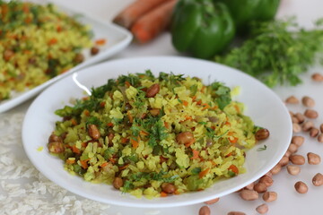 Vegetable Poha is a quick breakfast or snack made of beaten rice or flattened rice along peanuts, carrots and chilies.