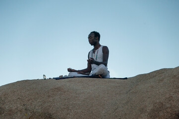Fototapeta na wymiar Photographs of a young black gay man practicing Reiki in the desert. 