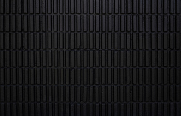 Black corrugated brick wall backgrounds pattern, old vintage brick wall backdrop, dark black brick old texture.
