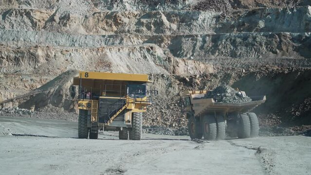 Large quarry dump truck transporting ore on open pit mine, slow motion