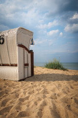 at the stand of the Baltic Sea there is a white beach chair