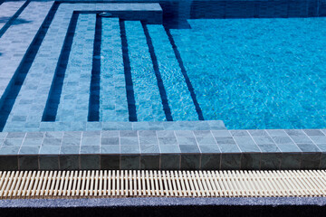 Outdoor swimming pool steps with clear water surface background, nobody, underwater pattern blue background with grid tiles, Summer background.