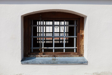 Historical window with a lattice. There is a white wall around the window.