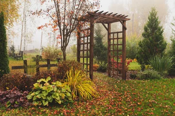 Rolgordijnen zonder boren wooden rustic archway in autumn natural garden. Foggy october day © mashiki