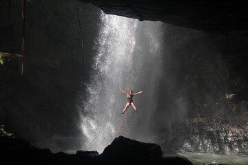 Mulher praticando pêndulo na cachoeira do funil, em mambaí, Goiás