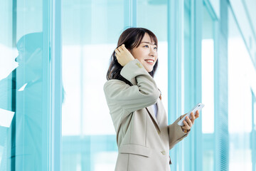 スマホを操作する笑顔のビジネスウーマン