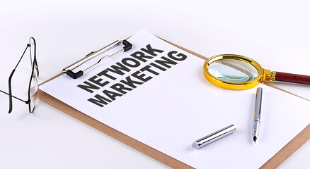NETWORK MARKETING text on clipboard on white background, business concept