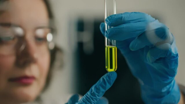 Experiment, A middle-aged woman Carefully holds a test tube with analyzes In a scientific laboratory. Specialist in microbiology At the workplace Applying modern technologies, chemicals
