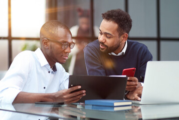 Businessman Using Laptop At Desk In Busy Office