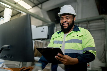 Two professional engineer,worker,technician use clipboard discuss work, walk in steel metal manufacture factory plant industry. Black African American man and woman wear hard hat check quality