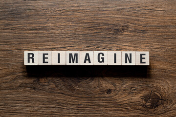 Reimagine - word concept on building blocks, text