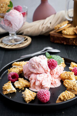 Raspberry ice cream in a bowl. on a dark background. Sweet dessert