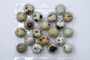 Quail eggs in plastic packaging. Quail eggs on a white background. A delicious snack.