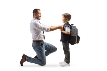 Full length profile shot of a father helping his son getting ready for school