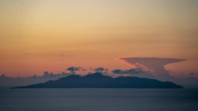 Time lapse of the Greek island of Anafi with very high altitude cloud in the tropopause developing and colouring at sunrise