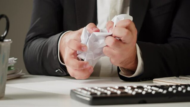 Aggressive man crumpling paper, stress at work concept. Mad impulsive crazy adult guy throwing away the documents, angry office worker 