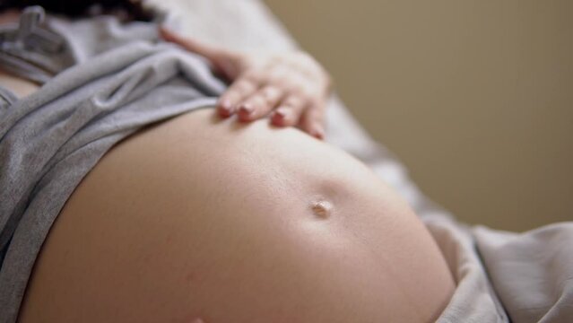 Pregnant woman awaiting for baby birth strokes belly