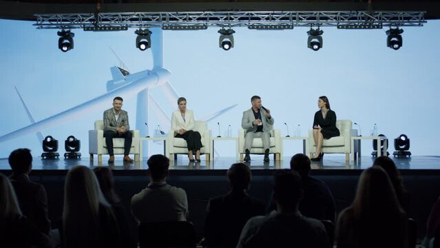 Group of 4 experts speakers are having a conversation on stage during sustainable green eco energy conference 
