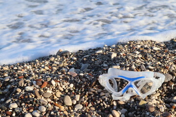 swimming goggles on the seashore, on the sea stones