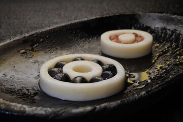 Concept. Imitation of a bearing made from food products such as hard cheese, salami sausage,...