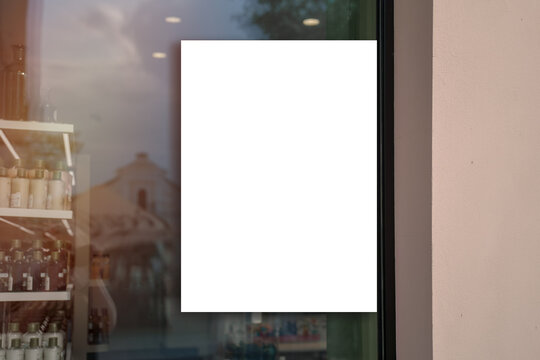 White vertical banner fixed on pharmacy or cosmetics store window glass outside