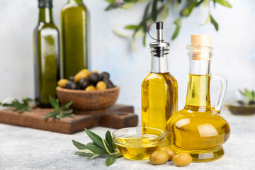 Olive oil in a bottle on a white texture background. Oil bottle with branches and fruits of olives. Place for text. copy space. cooking oil and salad dressing