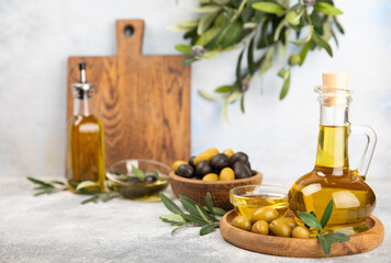 Olive oil in a bottle on a white texture background. Oil bottle with branches and fruits of olives. Place for text. copy space. cooking oil and salad dressing