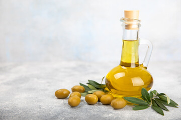 Olive oil in a bottle on a white texture background. Oil bottle with branches and fruits of olives. Place for text. copy space. cooking oil and salad dressing