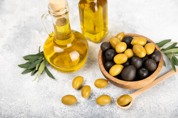 Olive oil in a bottle on a white texture background. Oil bottle with branches and fruits of olives. Place for text. copy space. cooking oil and salad dressing