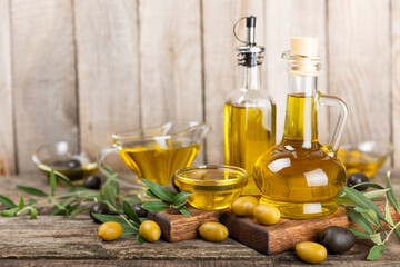 Olive oil in a bottle on a brown texture background. Oil bottle with branches and fruits of olives. Place for text. copy space. Cooking oil and salad dressing.