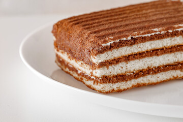 Cake multi-layered chocolate, on white board background, selective focus