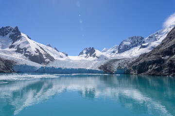 View of snow covered mountains with jagged peaks and floating ice at South Georgia Island's Drygalski Fjord