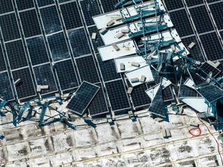Broken down photovoltaic solar panels destroyed by hurricane Ian winds mounted on industrial...