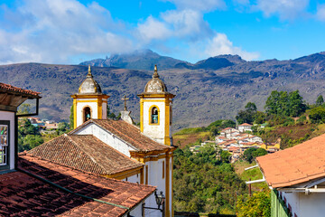 Fototapeta na wymiar Ancient colorful baroque church with mountains in the background in Ouro Preto city in Minas Gerais