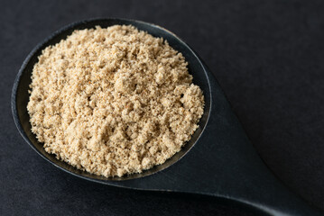 Ground Milk Thistle on a Black Spoon