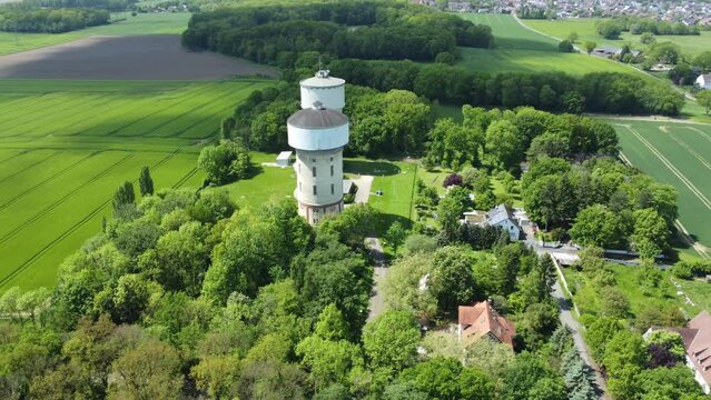 A smooth span overlooking two water towers, against a backdrop of green, cultivated fields, and trees. Water towers in Hamm, Germany.