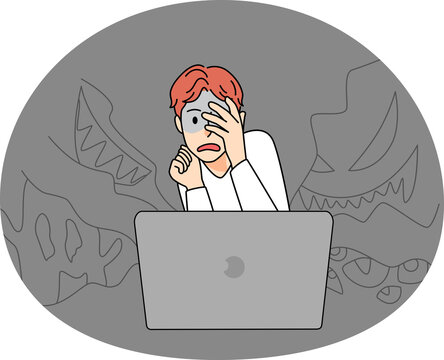 Scared boy watch horror movie on computer