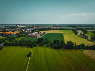 Aerial view of Poasco in Italy surrounded by fields and countryside. Milan, Lombardy Aerial photo. Top view of countryside and green fields. Country Life Concept. Aerial photography in the summer.  