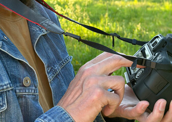 Photographers hands adjusting camera, DSLR equipment closeup