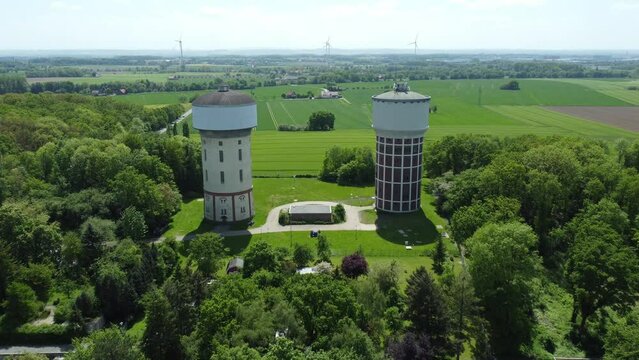 A smooth span overlooking two water towers, against a backdrop of green, cultivated fields, and trees. Water towers in Hamm, Germany.