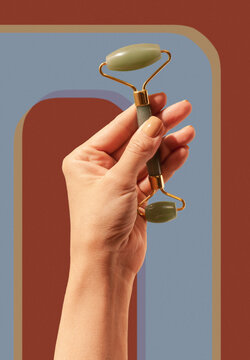 Cosmetic stone green massage roller tool in woman hand