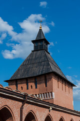 Old Tula Kremlin red brick wall and tower with wooden roof in sunny summer day. Clear blue sky with few clouds. Medieval architecture. Travel in Russia theme.