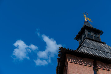 Fototapeta na wymiar Old Tula Kremlin red brick wall and tower with wooden roof in sunny summer day. Clear blue sky with few clouds. Medieval architecture. Copy space for your text. Travel in Russia theme.