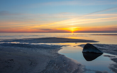 Seascape at sunset. Blue hour. The last rays of the sun color the sky. The night is coming. Latvia. Baltic Sea.