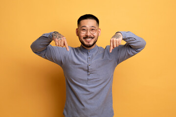 Look At This. Smiling Asian Guy Pointing Down With Two Hands