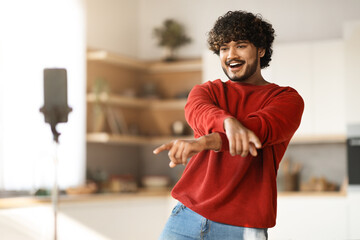 Handsome Indian Male Dancing At Smartphone Camera While Recording Video At Home